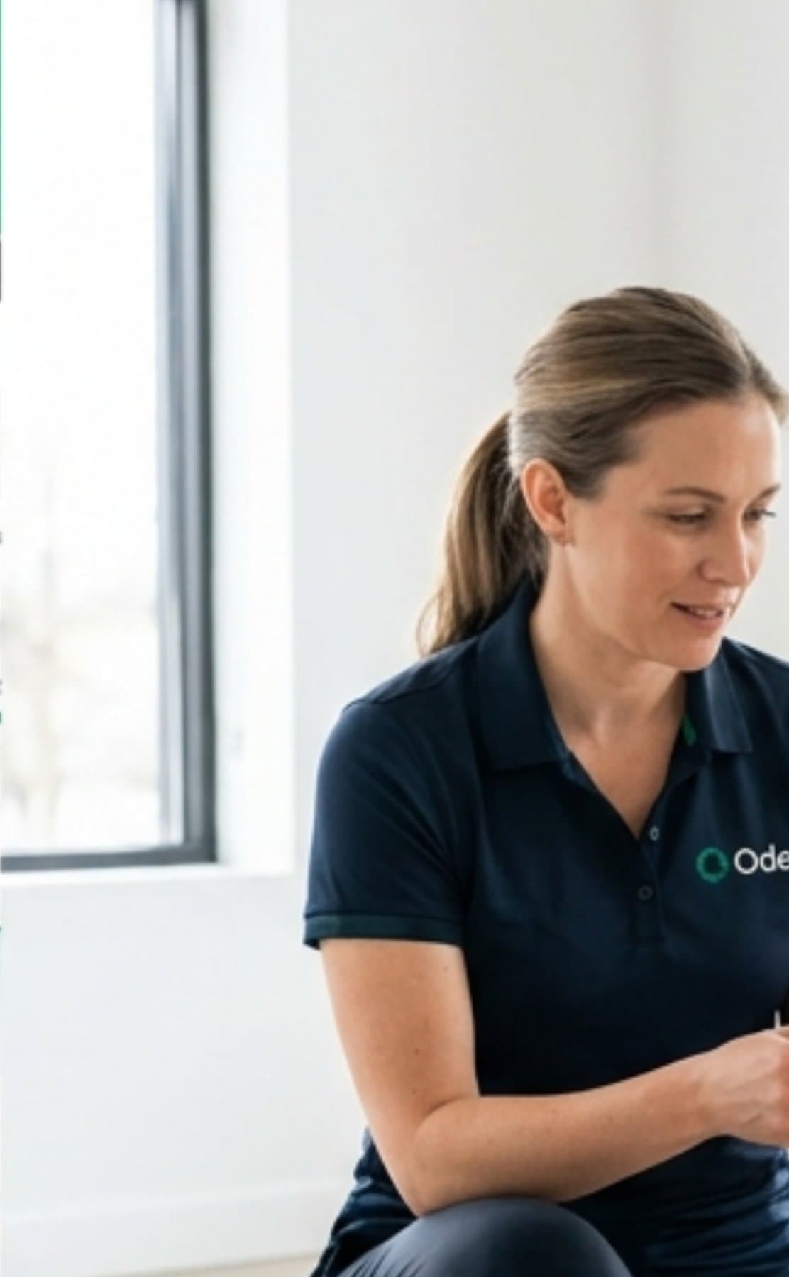A pet professional in Oden branded apparel reviewing session notes